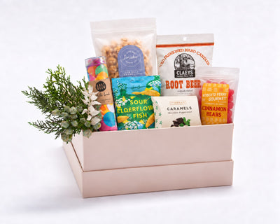 Celebration Gift Box: Knot & Bow confetti bomb, BonBon sour elderflower fish, Sir Walter caramel popcorn, Claeys root beer candies, McCrea's caramels, Roberts Ferry cinnamon bears and greenery in a blush gift box