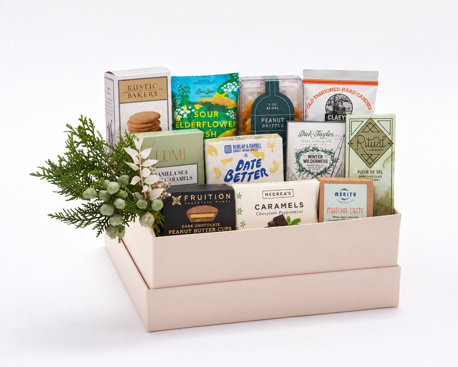 Deluxe Sweet Gift Box: eleven artisan sweets including Rustic Bakery vanilla cookies, BonBon sour elderflower fish, Lumi vanilla sea salt caramels, Fruition peanut butter cups, Date Better baklava dates, Dick Taylor and Ritual chocolate, with holiday greenery