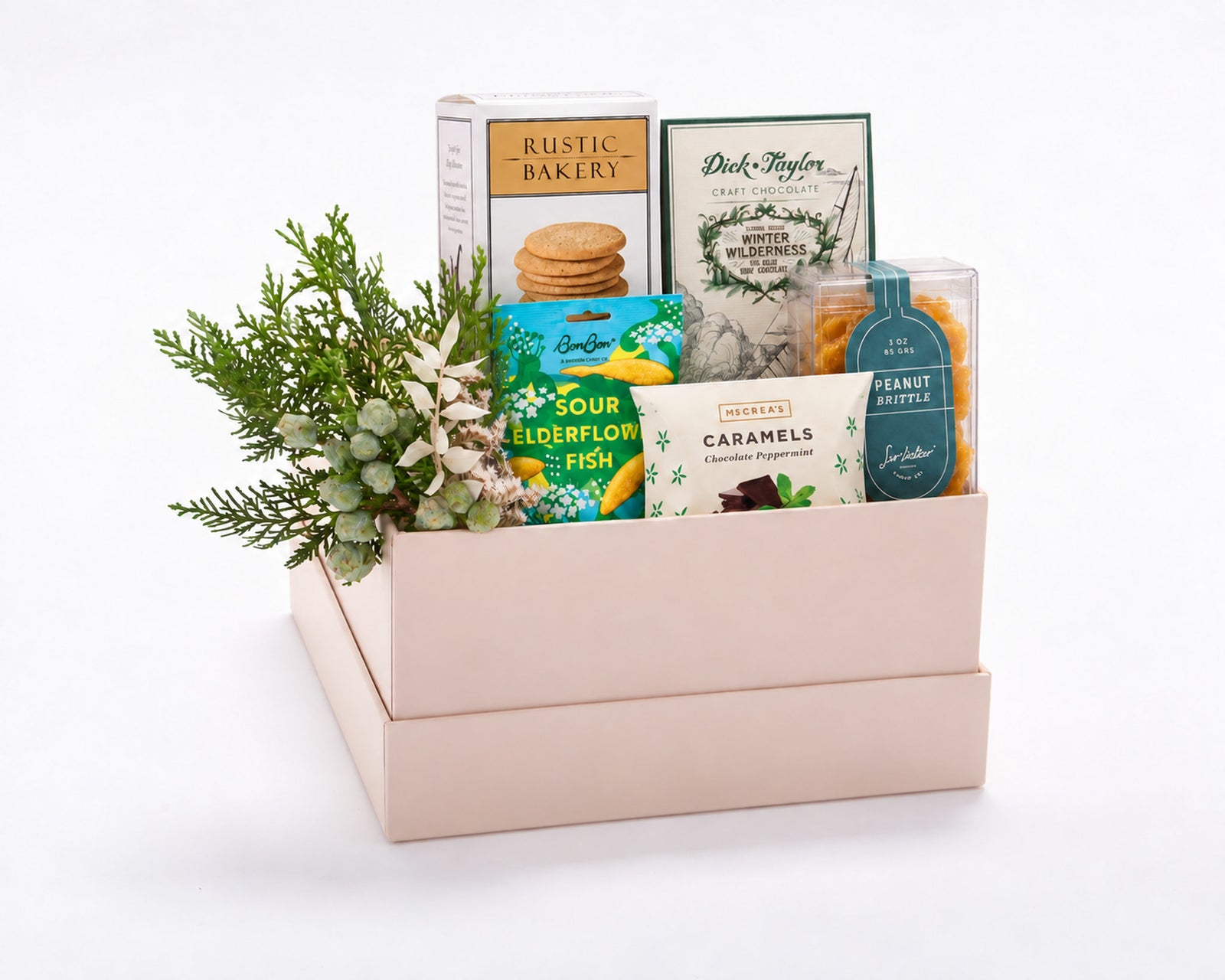Petite Sweet Gift Box: Rustic Bakery Madagascar vanilla cookies, BonBon sour elderflower fish, Dick Taylor Winter Wilderness chocolate, McCrea's chocolate peppermint caramels and Sir Walter Candy Co. peanut brittle with holiday greenery