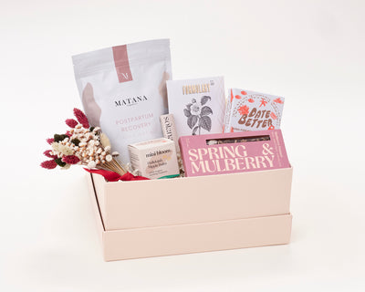 New Mom Gift Box with Matana Sitz bath soak, Mini Bloom Nipple Balm, Solana Lip Butter, Formulary 55 Face Mask, Date Better Peanut Butter Crunch, and Spring and Mulberry Chocolate Bar.