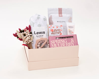 New Mom and Baby Gift Box with Matana Sitz bath soak, Mini Bloom Toot Toot Diaper Cream, Spring and Mulberry Chocolate Bar, Date Better Peanut Butter Crunch, Lewis Burp Cloth Set, and Marlowe and Sage Cloud Teether.